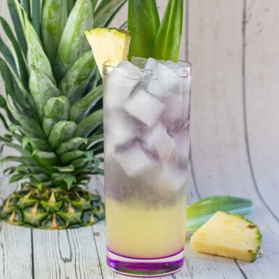 皇家夏威夷鸡尾酒，上面装饰着菠萝楔子和叶子。
